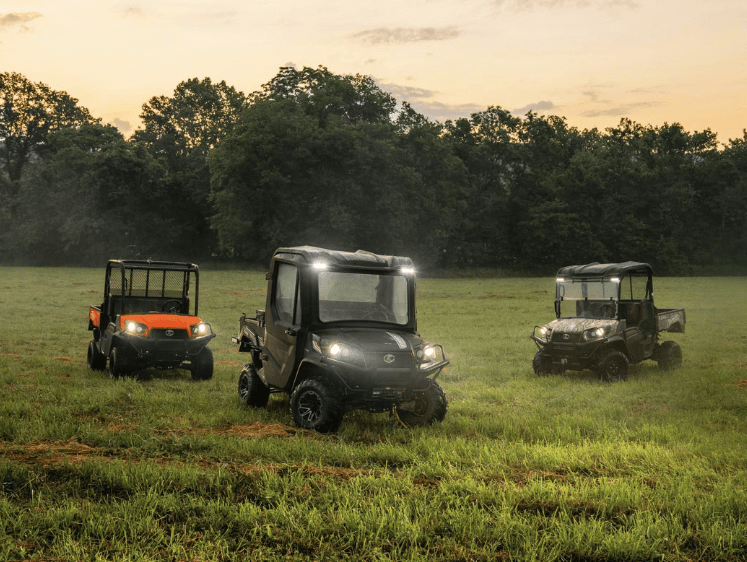 Utility Vehicles driving in an open pasture