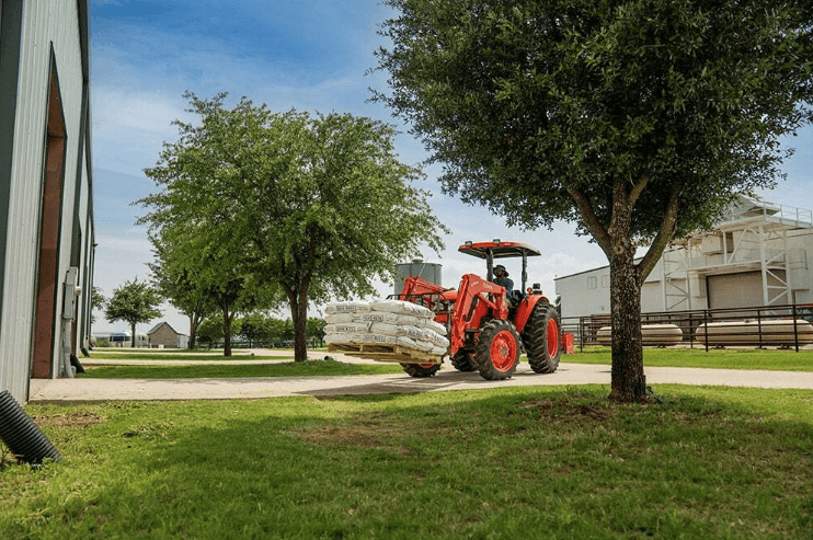 Tractor moving material with a pallet
