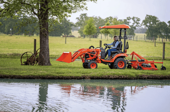 Woman driving tractor close to a pond