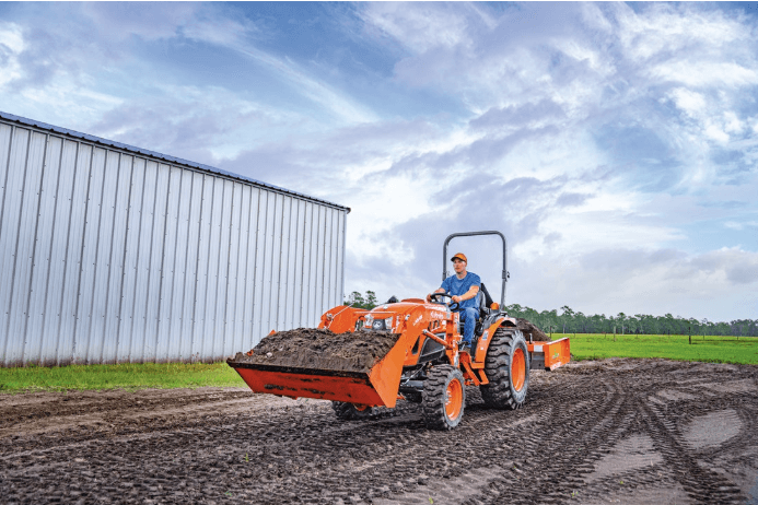Man driving tractor through mud
