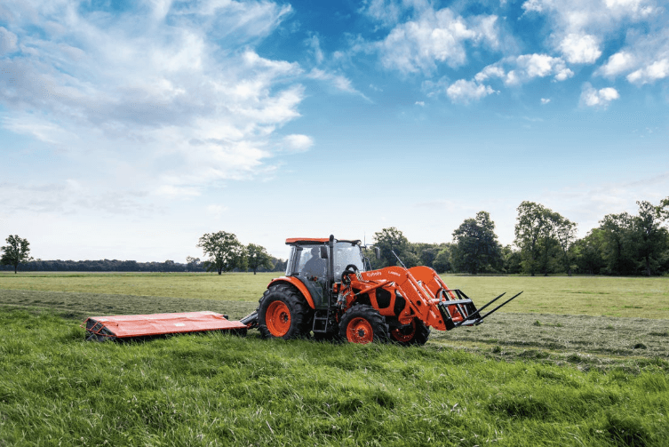 M5 Series tractor moving field with a disc mower