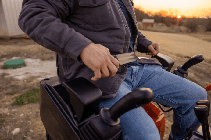 Close up of an operator strapping into a Kubota excavator