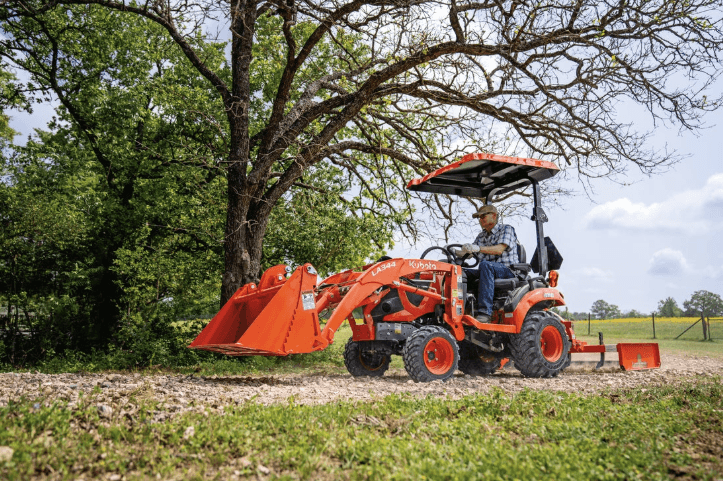 Man driving tractor with rear attachment