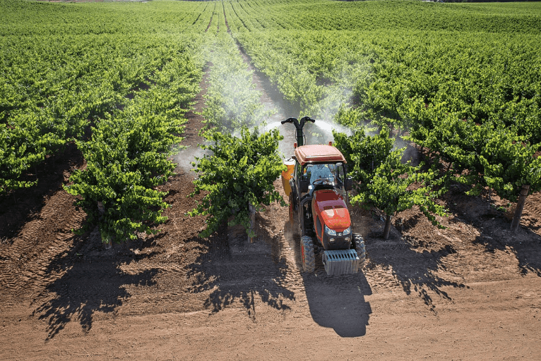 Tractor spraying rows of crops