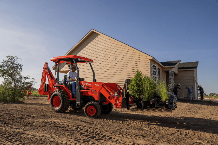 Tractor Loader Backhoe transporting a pallet of palnts