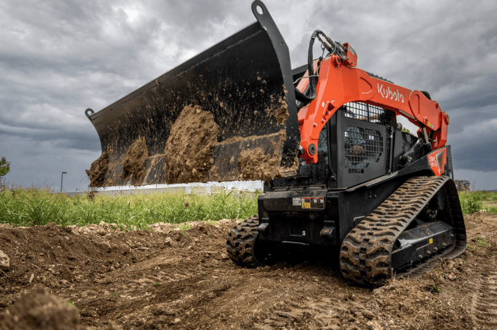 Track loader dumping dirt